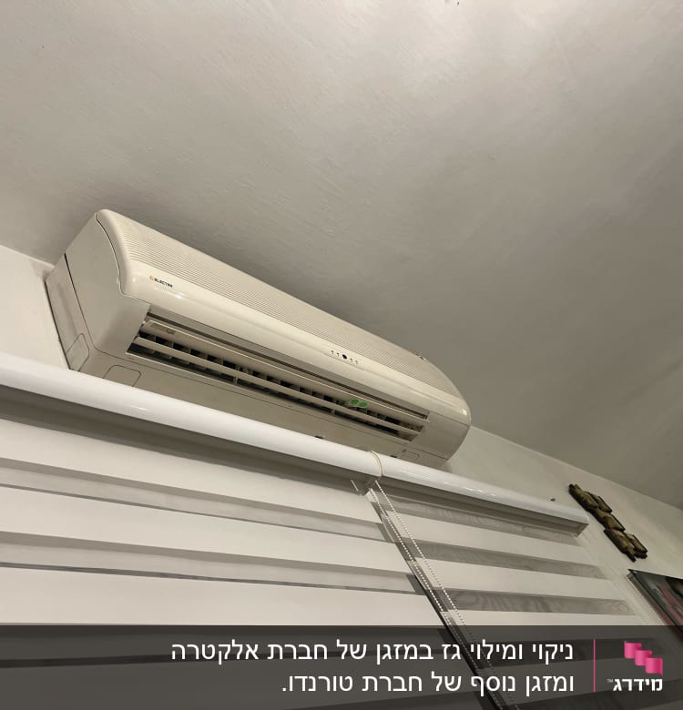 מזגן מותקן על קיר מעל תריסים לבנים